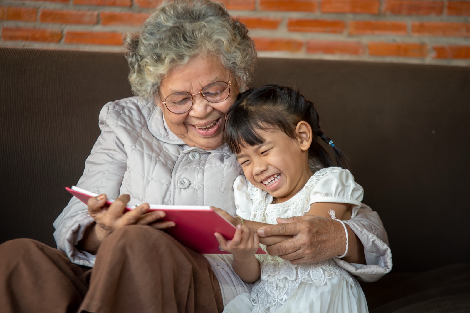 A grandmother and grandchild looking through an old photo album together.